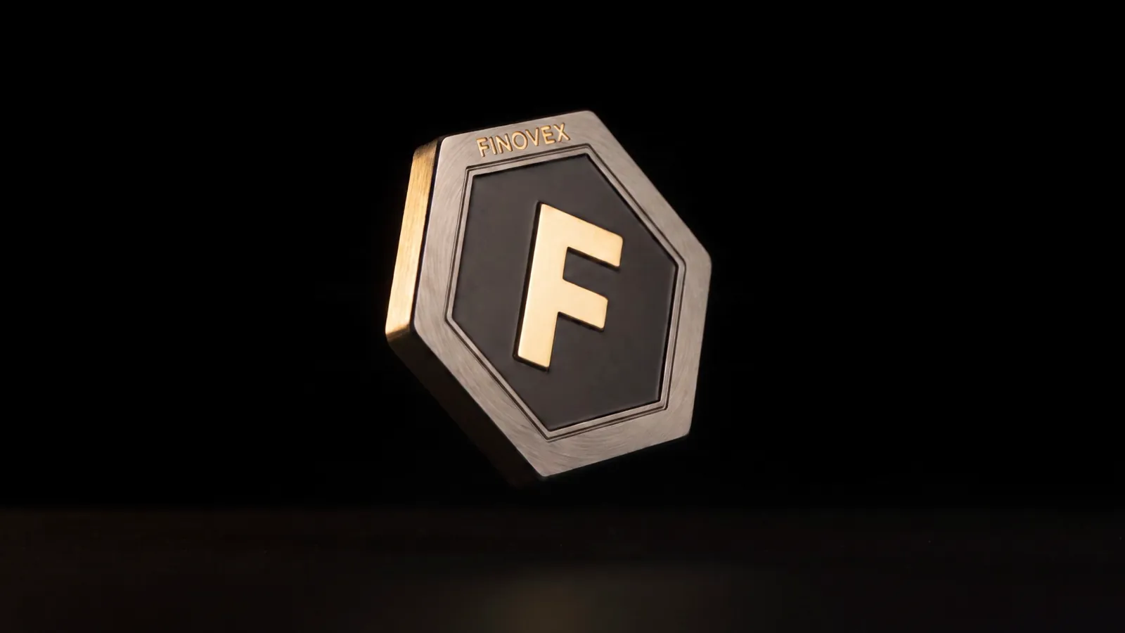 Finovex Token suspenso na escuridão, revelado por uma luz lateral