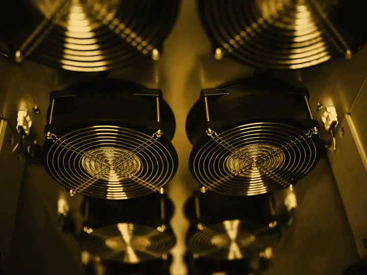 Ventiladores industriais de refrigeração de um data center, iluminados em âmbar