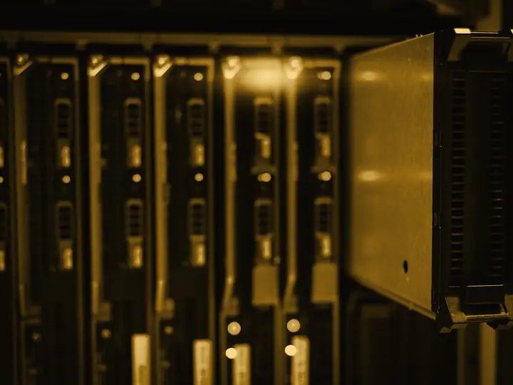 Módulos de processamento em um rack de servidores, iluminados em âmbar